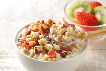 ミルクを注いだ朝食のシリアルやフレークと果物