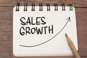 Sales growth, text words typography written on book against wooden background, life and business...