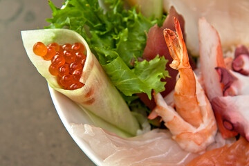 Sashimi Japanese food, fish in mixed slices on a white plate. Sashimi with salmon, fish, shrimp, tuna, on stone background