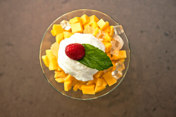 Mango cup with liche and raspberry ice cream on Stone background, Ice cream cup with fruit, top view