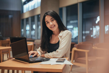 Young woman working on laptop at night. businesswoman smiling and working in office at night.