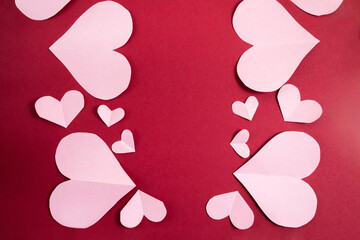Paper hearts of different sizes on a burgundy background. Abstract background with paper cut shapes.Sainte Valentine,mother's day. birthday greeting cards, invitations.Template for design.Copy space.