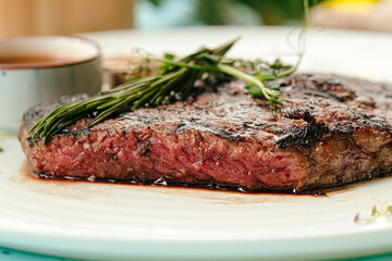 Closeup on roasted beef medium rare steak with a rosemary
