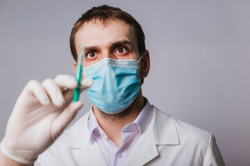 The doctor holds a syringe with a vaccine. Vaccination and immunization of the population against coronavirus. Studio photo