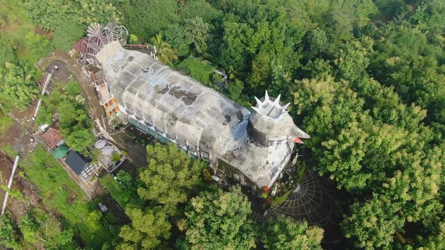 Aerial tilt up view of Chicken Church to reveal evergreen tropical forest, Java