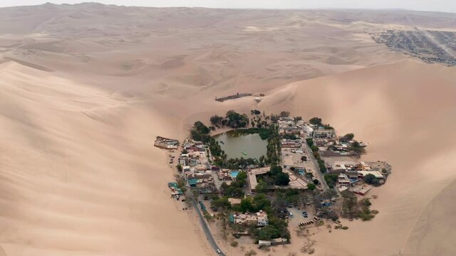 Aerial view above the small village of Huacachina Peru, A small village around a desert oasis surrounded by sand dunes.
