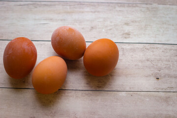 Four red chicken eggs on a wooden background