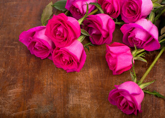 beautiful pink roses on a wooden table