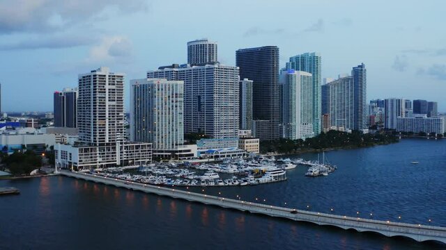 Cars Driving Across A Bridge Towards A Harbor And City Skyscrapers Aerial