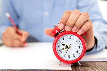 The alarm clock in front of the desk during the exam