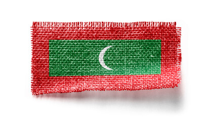 Maldives flag on a piece of cloth on a white background