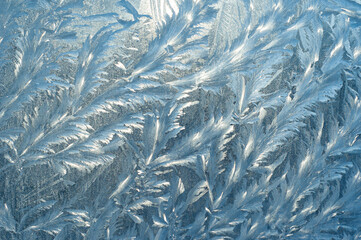 Frosty patterns on the window at dawn. Frosty window texture. Abstract background.
