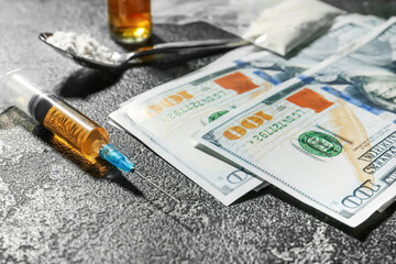 Syringe, drugs and money on dark background