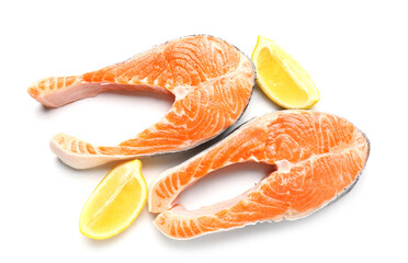 Raw salmon steaks and lemon on white background