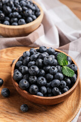 Bowls with tasty ripe blueberry on table