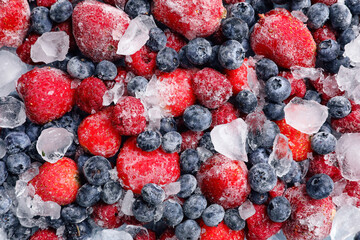 Different frozen berries and ice as background