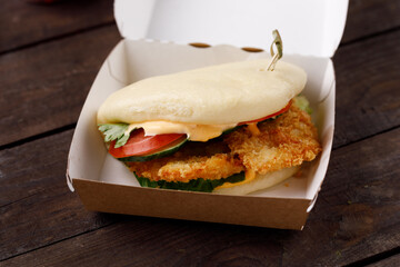 Bao buns.Hawaiian food dish, in a box on a wooden table. Pan-Asian cuisine to go or delivery in container. Close-up