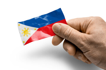 Hand holding a card with a national flag the Philippines
