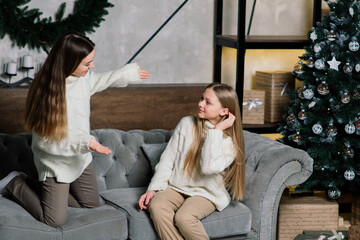 Girlfriends celebrating New year eve and Christmas and eating mandarins. Gifts, decorated fir.