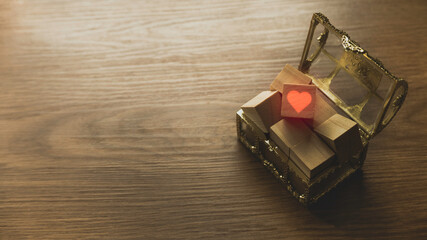 Selective focus of treasure box fill with wooden box and one of it with Love or heart symbol on wooden background with copy space