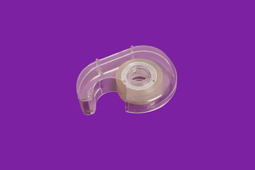 scotch tape dispenser isolated on purple background