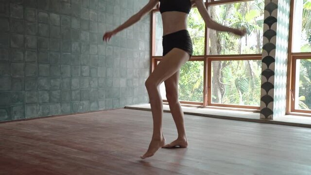 Young adult skinny european woman performing contemporary dance improvisation in studio. Graceful modern style dancer expressing inspiration and emotions in dance moves.