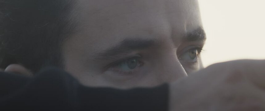 Archer man's eyes extreme close up draw aim and release shoot a bow