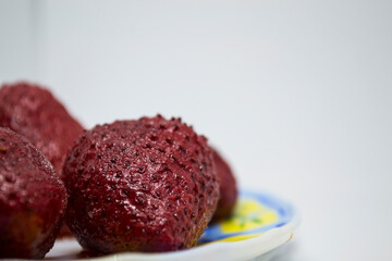 Frozen strawberries on a saucer. White background.