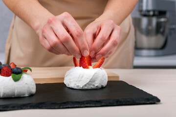 Obraz na płótnie Canvas Pastry chef prepares berry dessert. Strawberry cake decorating process