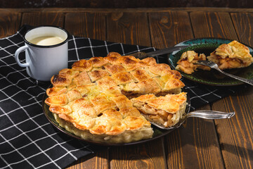 apple pie with milk on a wooden background. Rustic style.