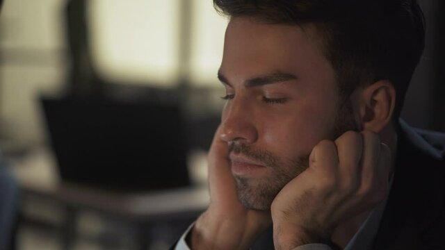 Portrait of young businessman, manager works late, overworked guy at work, a tired falls asleep in the workplace, night time.