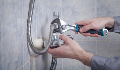 Man repair and fixing shower faucet in bathroom.