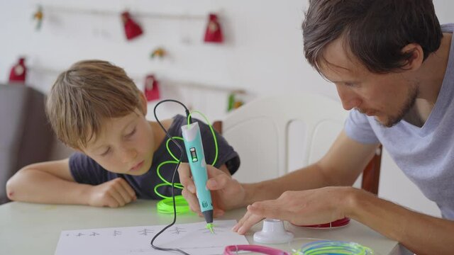 Father shows his son how to use a 3d pen