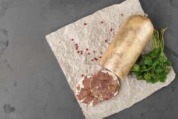 Liver sausage on parchment with parsley on gray background