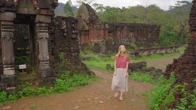 A young woman tourist is walking through ruins in the My Son Sanctuary, remains of an ancient Cham civilization in Vietnam.Tourist destination in the city of Danang. Travel to Vietnam concept