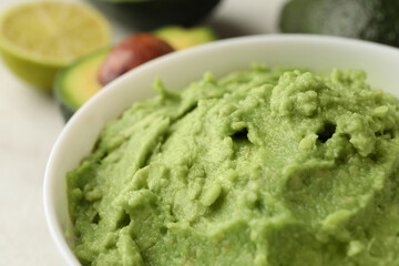 Bowl of guacamole, avocado and lime, close up