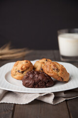Cookies on a wooden table with a glass of milk and wheat ear