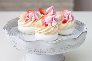 Mini pavlova cakes with chocolate hearts, fresh strawberries and red heart shaped sprinkles