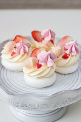 Mini pavlova cakes with chocolate hearts, fresh strawberries and red heart shaped sprinkles