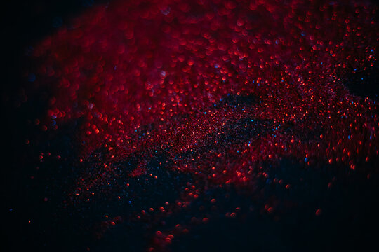 Red Sand From Sequins. Scattered Sparkles On A Black Background. Space Texture. Stars