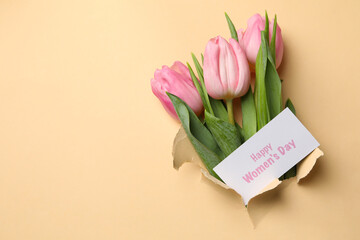 Tulips and text Happy Women's Day through beige paper hole