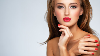 Model with fashion makeup.. Face of young woman with red lipstick and long brown hair.