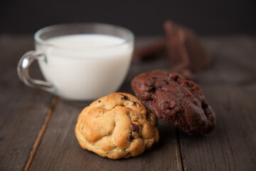 Cookies on a wooden table with a glass of milk