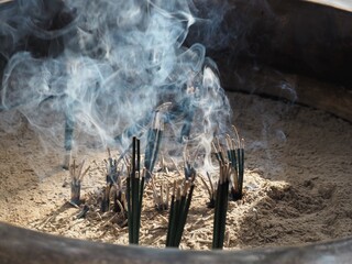 お寺の燭台で燃える線香