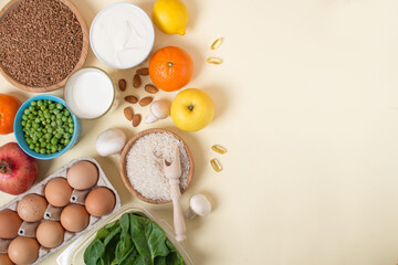 Obraz na płótnie Canvas a set of useful foods and vitamins on a light yellow background.