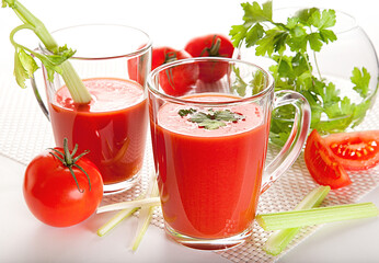 Fresh tomato juice with celery and parsley in a glass on a white table. Vitamins, natural, healthy...