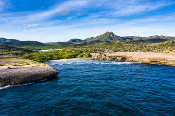 Aerial view above scenery of Curacao, Caribbean with ocean, coast, hills, lake