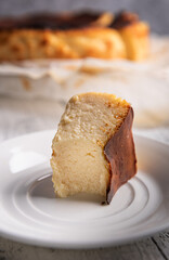Close-up of bitten portion of basque burnt cheesecake on white plate