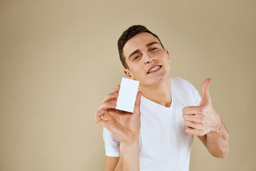 Man with a business card in the hands of an office manager beige background Copy Space