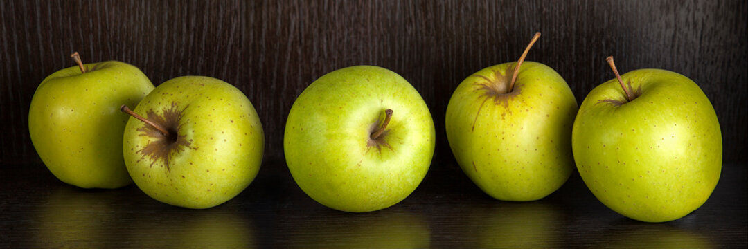 Green apples on dark wooden background